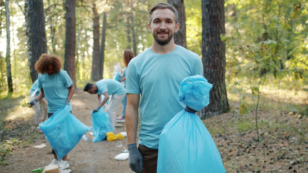 volunteer hours — Man with trash bag in park cleanup