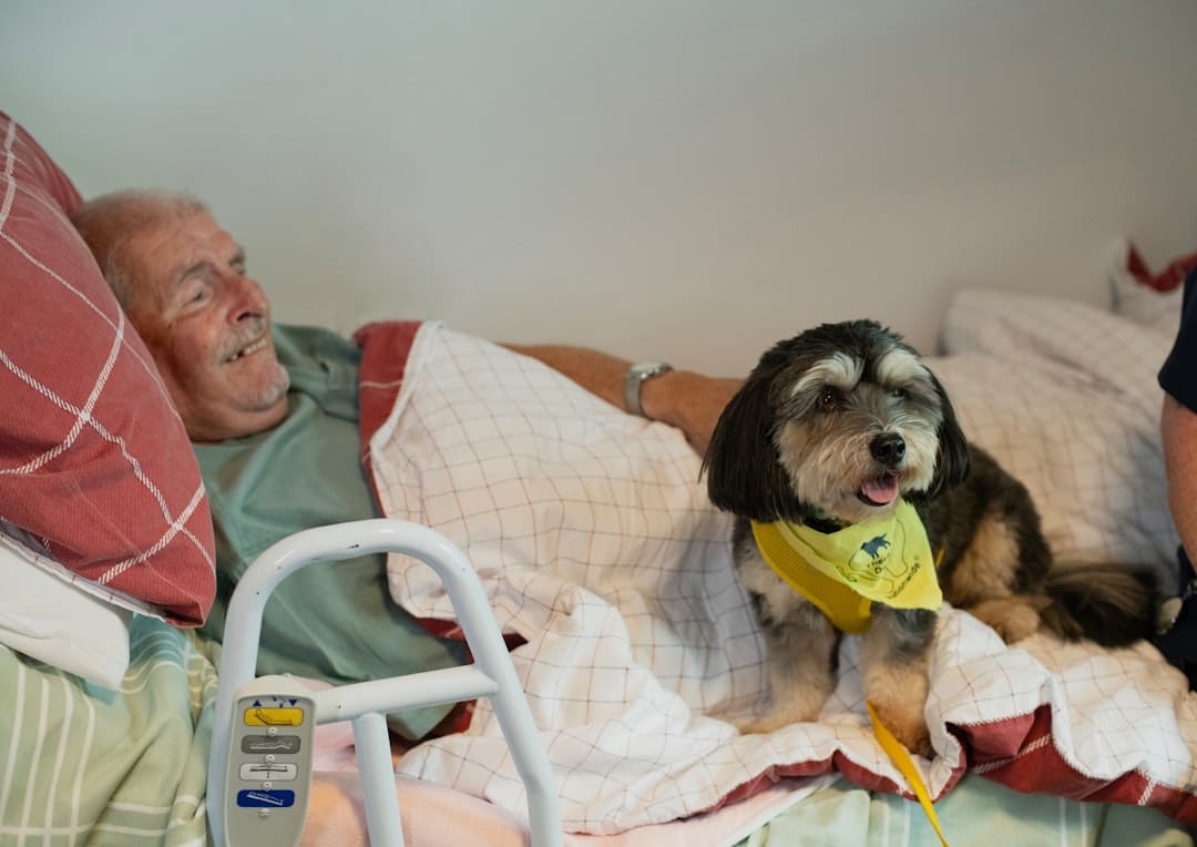 therapy dogs children' s hospitals. Elderly man and dog in bed