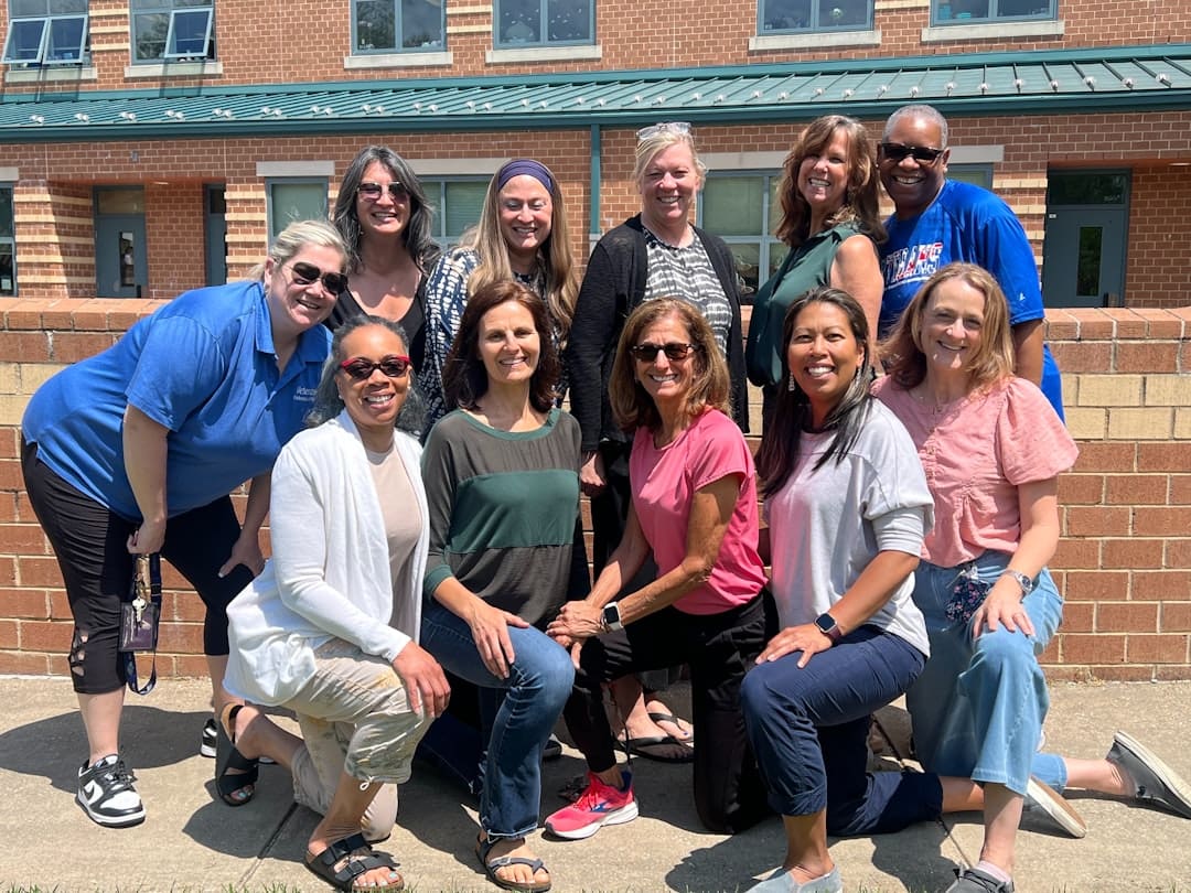 therapy dog volunteer hours — A group of smiling people pose for a photo.