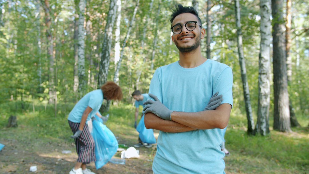 handler grief — Man smiling in park with volunteers cleaning up